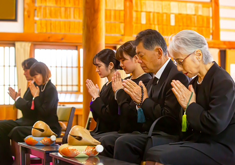 葬儀屋さんのゆいまーるで府中市の式場にて家族が一日葬の告別式で手を合わせている
