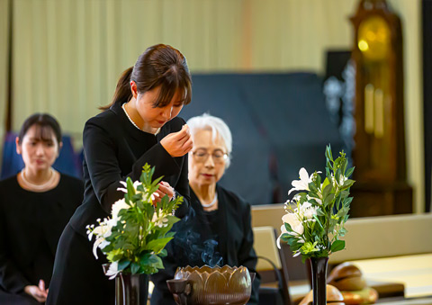 葬儀屋さんのゆいまーるで府中市の式場で家族葬の焼香をする遺族