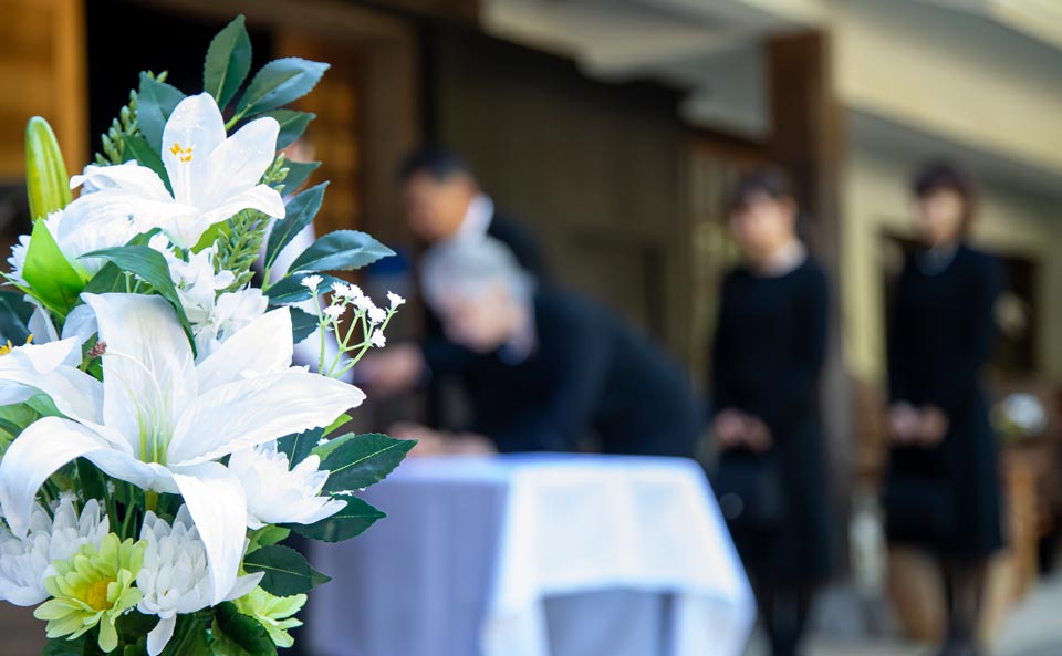 葬儀屋さんのゆいまーるが府中市で家族葬の式場に飾られた白百合の祭壇装花に寄り添う風景