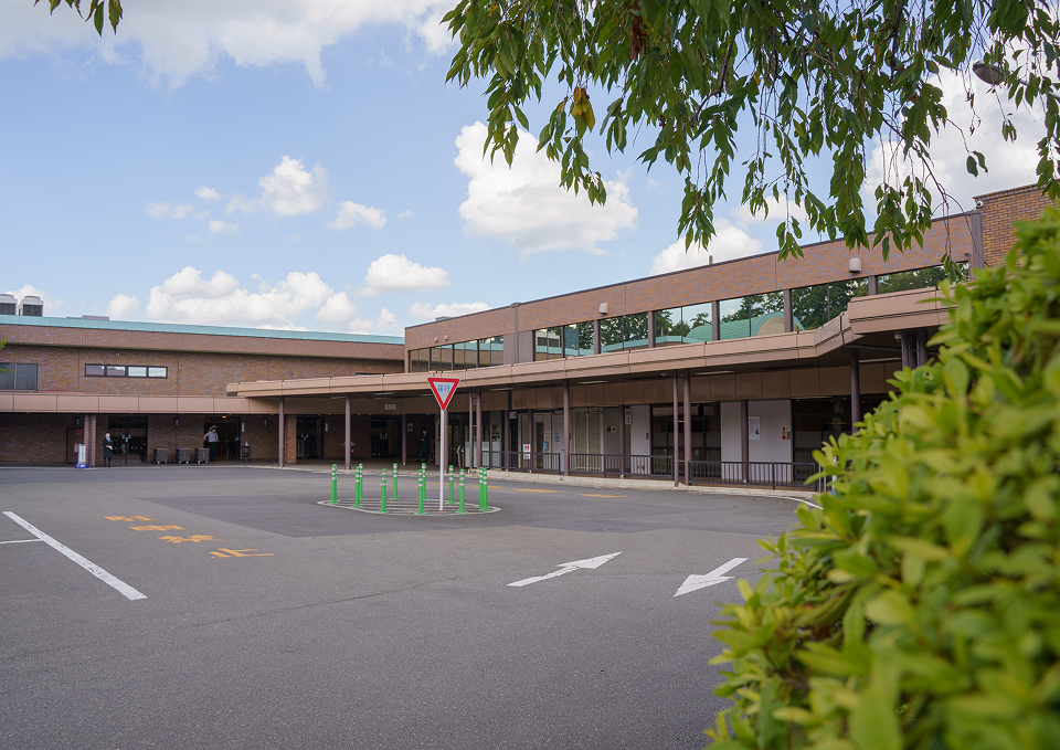 府中の森市民聖苑前の広い駐車場に面した斎場入口で葬儀準備をする葬儀屋さんのゆいまーるの受付風景、府中市での家族葬に対応