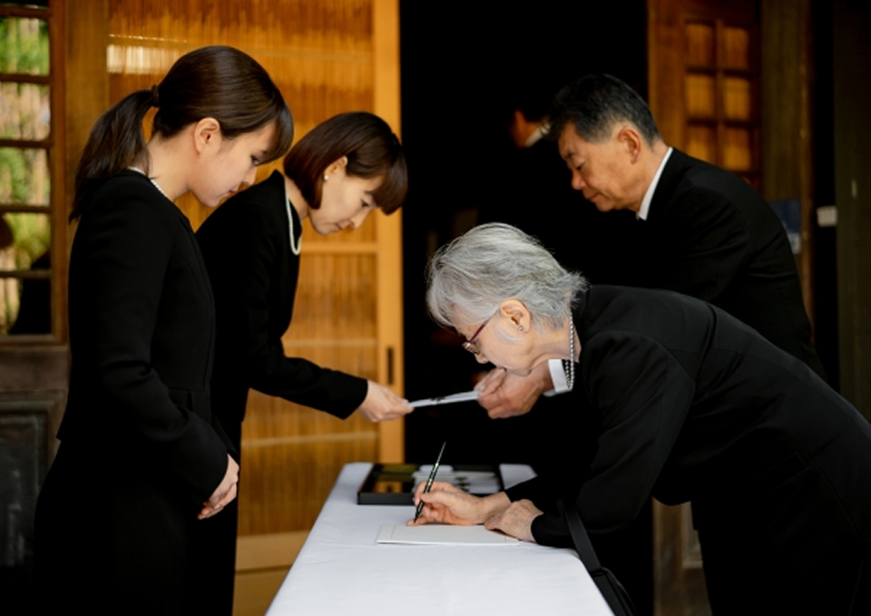 葬儀屋さんのゆいまーるが府中市で受付台に来場者の氏名を記帳している