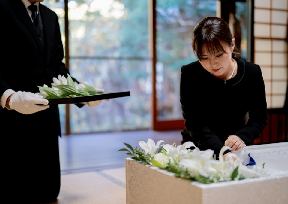 葬儀屋さんのゆいまーるが府中市で遺族と花を添えて納棺の準備をしている