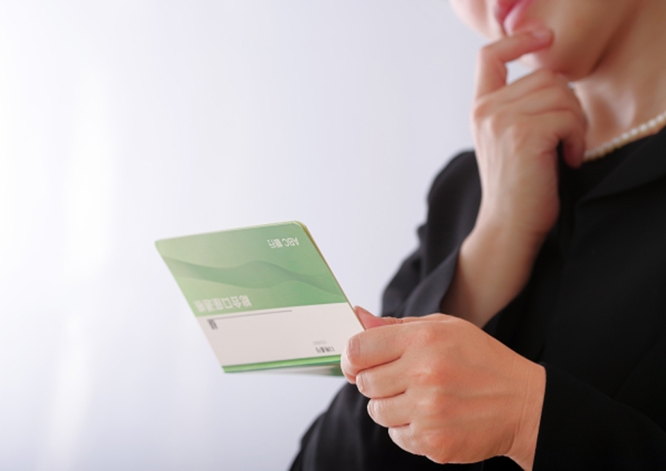 葬儀屋さんのゆいまーるが府中市で一日葬の案内パンフレットを手に説明を考えている女性