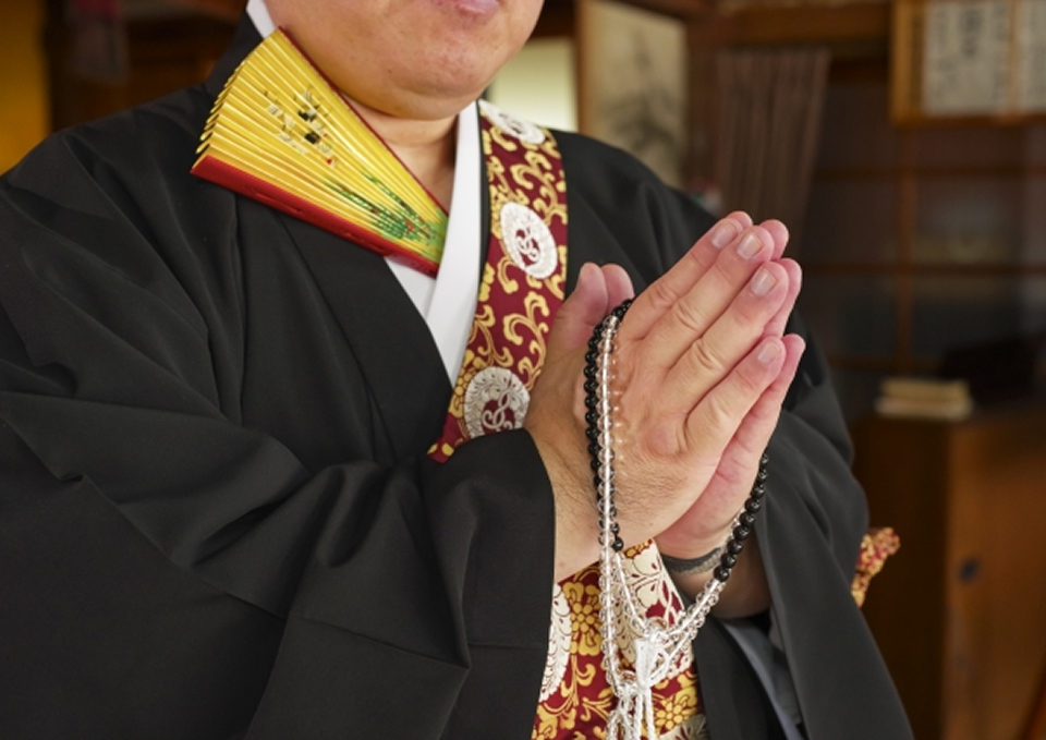 葬儀屋さんのゆいまーるが府中市で袈裟を着た僧侶と数珠で合掌する一日葬の場面