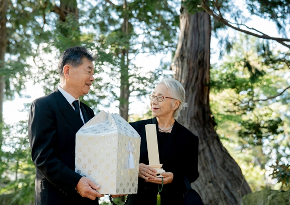葬儀屋さんのゆいまーるが府中市で遺骨と祭壇を手にした高齢夫婦に見送られる一日葬の場面