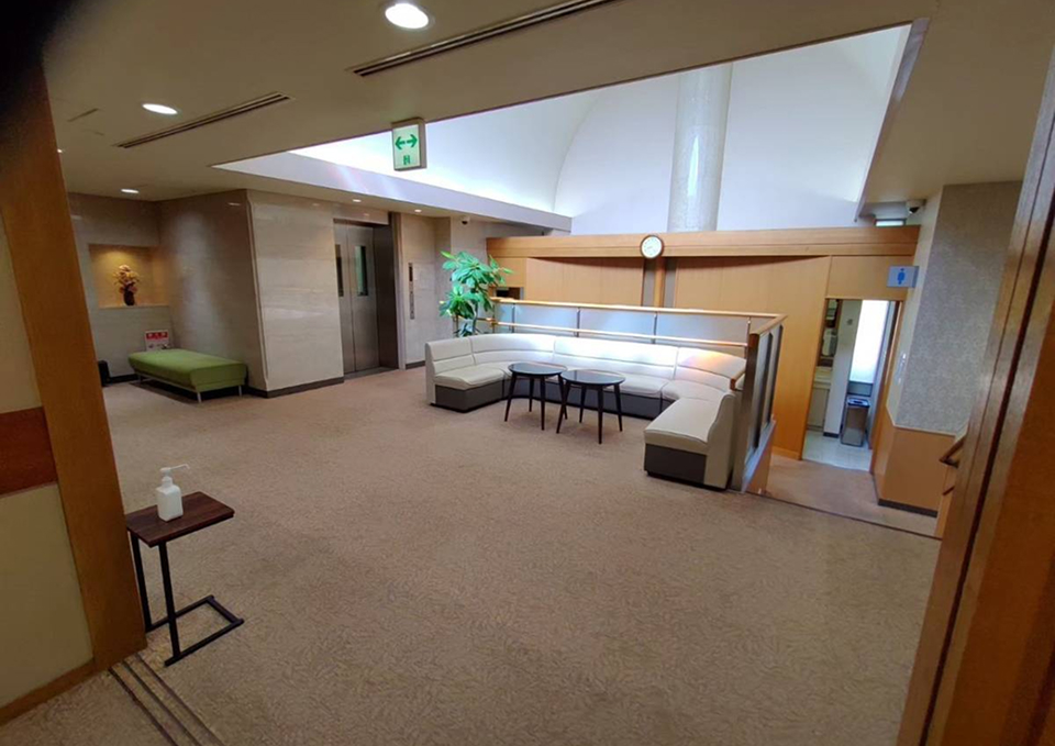 日華斎場の待合ロビーで白いソファに座る喪主がいる風景 — 葬儀屋さんのゆいまーるが府中市で案内