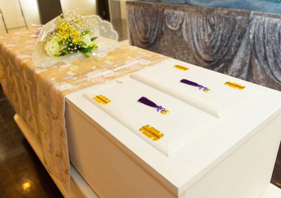 葬儀屋さんのゆいまーるが府中市で白木の棺と献花を用いた火葬式の出棺準備を行っている