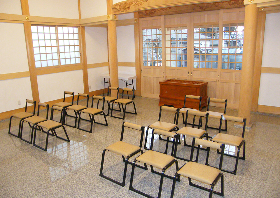 葬儀屋さんのゆいまーる案内のもと医王寺の式場に並んだ椅子と祭壇、府中市からのアクセス案内に適した室内風景