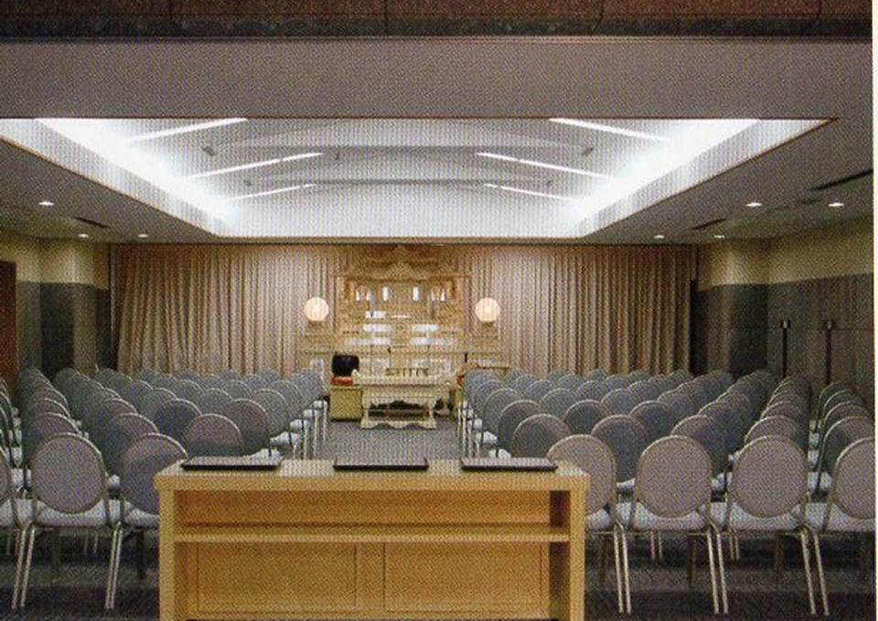 南多摩斎場の第一式場で椅子約100脚が整列した祭壇前の会場、葬儀屋さんのゆいまーるが府中市向けに案内中
